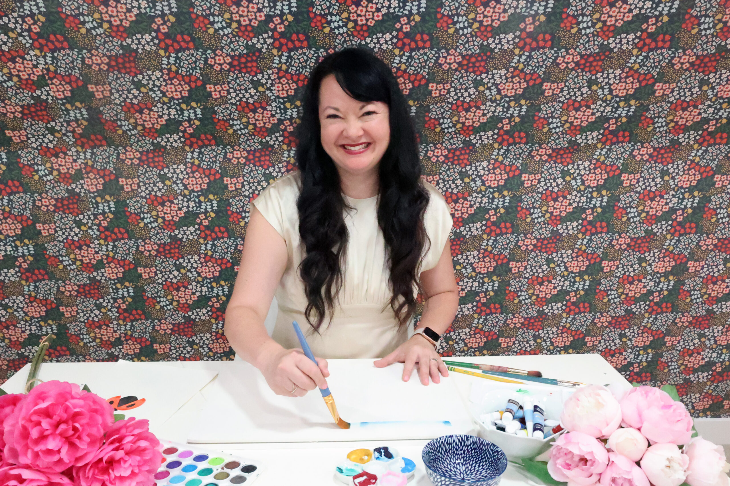 Carina Gardner painting at her studio desk