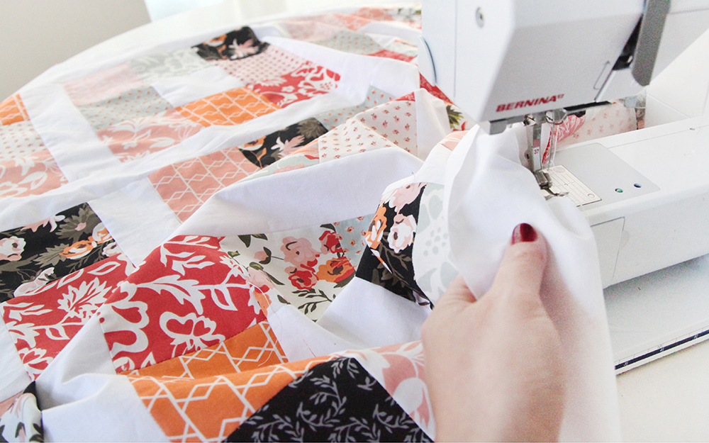 Colorful quilt fabric being sewn on a Bernina machine